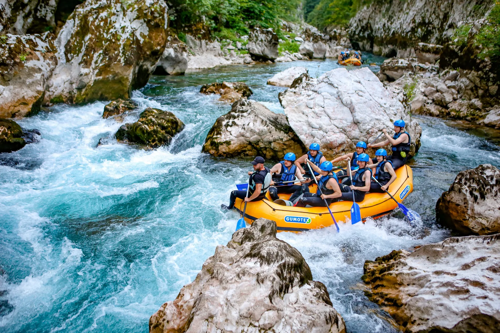 Rafting team navigating through thrilling rapids on the emerald Neretva River, surrounded by dramatic canyon walls in Bosnia and Herzegovina
